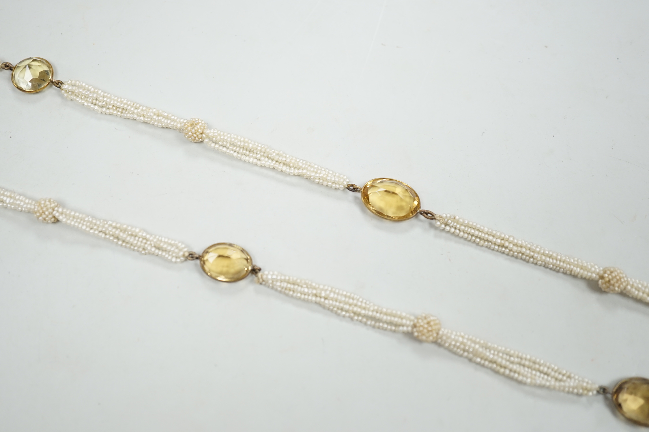 A 19th century Indian multi strand seed pearl and oval cut citrine set long necklace, with gem set tassel drops, 166cm.